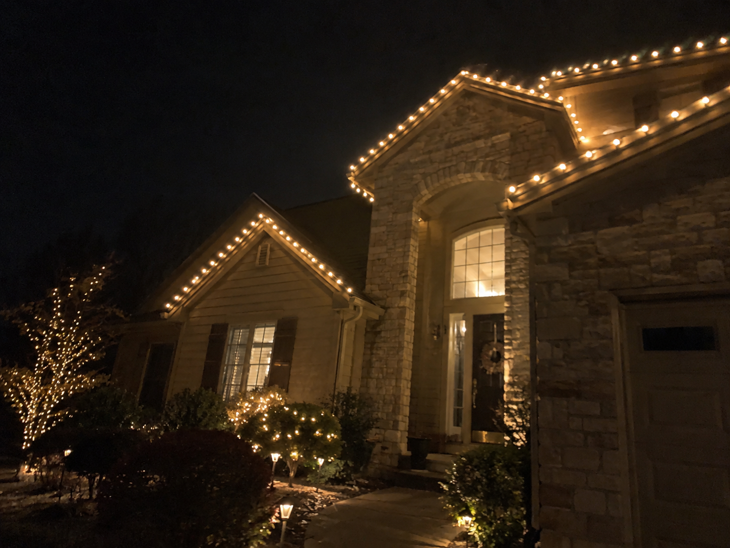 Stone entryway outlined in holiday lights